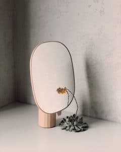 Fleur jaune devant un miroir en bois
